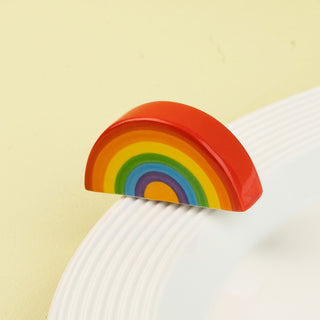 Colorful rainbow-shaped mini on a white plate against a light green background