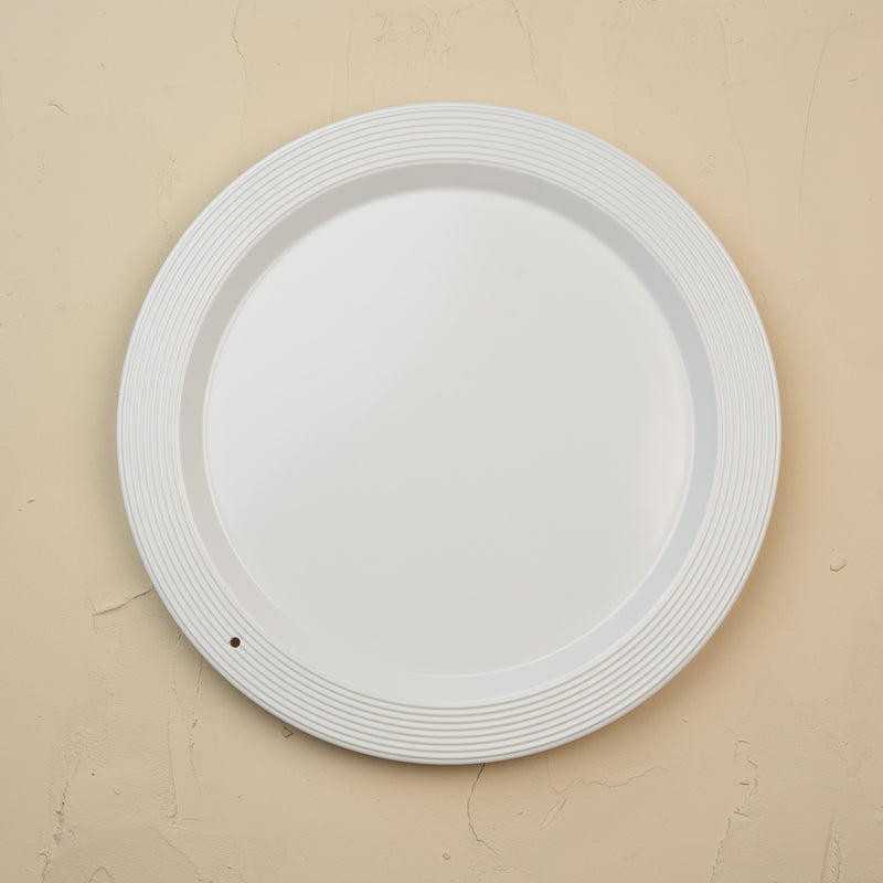 White melamine round platter on a beige background