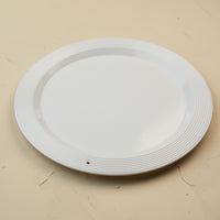 White melamine round platter on a beige background