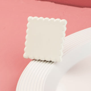 White square scalloped mini on a white plate with a red background