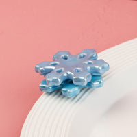 Blue snowflake-shaped mini on a white background with a pink gradient