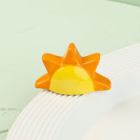 Sun-shaped mini with orange and yellow gradient on a white surface with a light green background