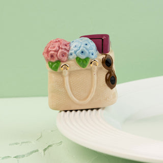 a tote bag mini filled with flowers, a book and sunglasses