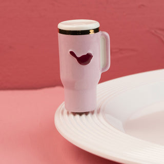Pink travel mug mini with a bird design on a pink background