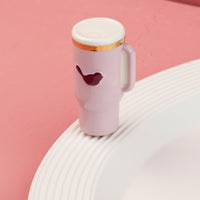 Pink travel mug mini with a bird design on a pink background