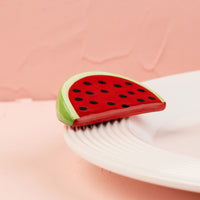 Watermelon-themed mini on a white plate with a pink background