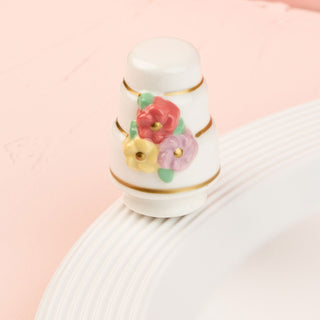 a white wedding cake mini with colorful flowers on a pink background