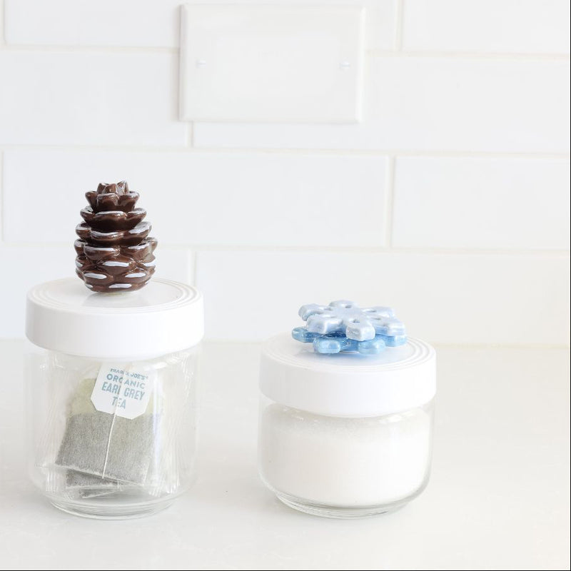 snowflake mini on container next to pinecone mini and snowman mini