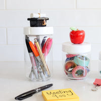 graduation hat mini on a large container, apple on medium container and happy face on small container